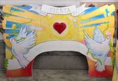 Twelve-foot wide arch painted with doves and banners around a heart.